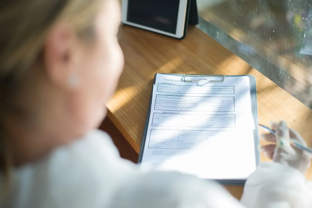 A woman filling out an application form at a desk