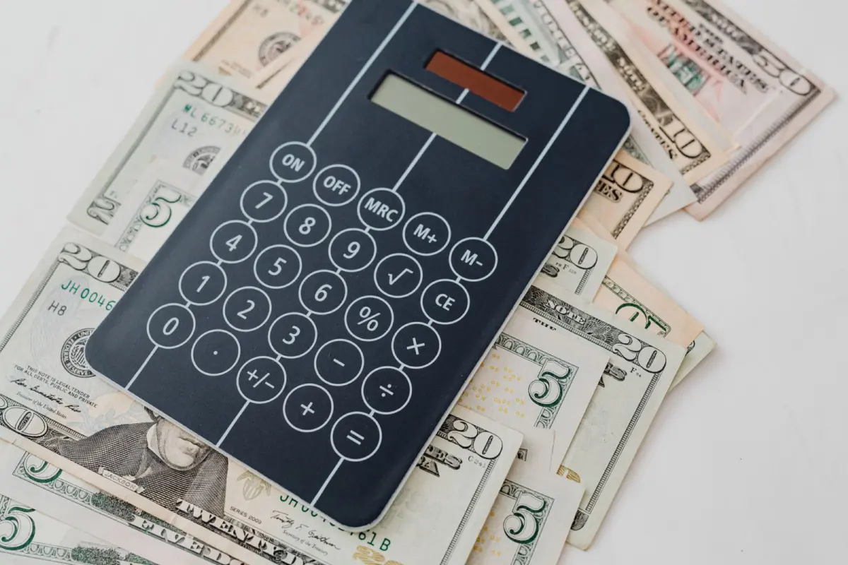 A calculator on top of US dollar bills